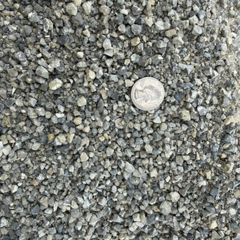 Close-up of gray and tan Dry Creek Pathway Chat with a quarter for scale