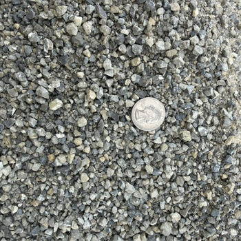 Close-up of gray and tan Dry Creek Pathway Chat with a quarter for scale